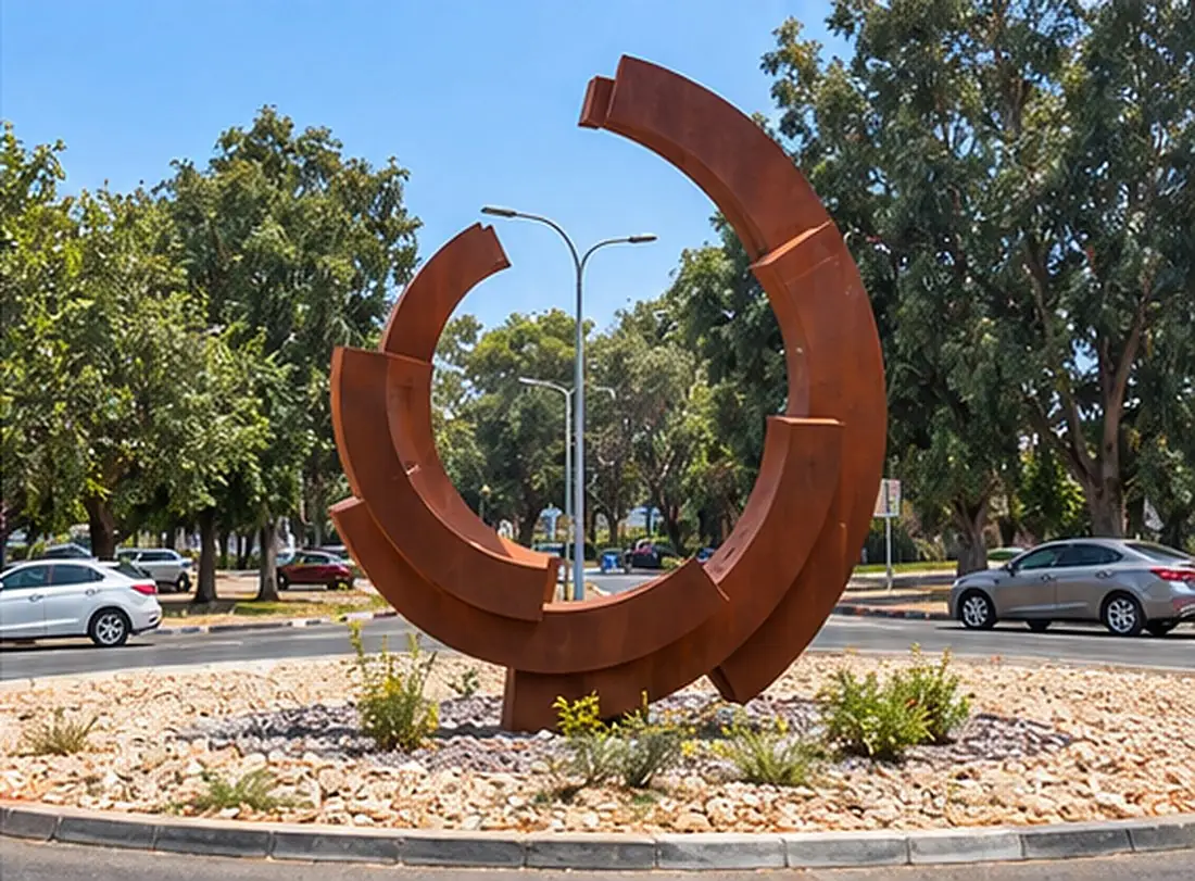 קשתות קורטן מעגליות שבורות, בכיכר מוקפת עצים