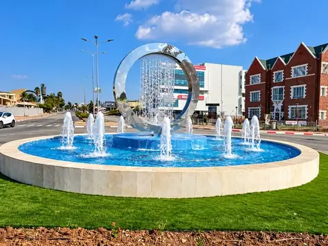 מזרקת הספירלה ביום: טבעת הנירוסטה, וילון המים והסילונים בבריכה העגולה, בעפולה